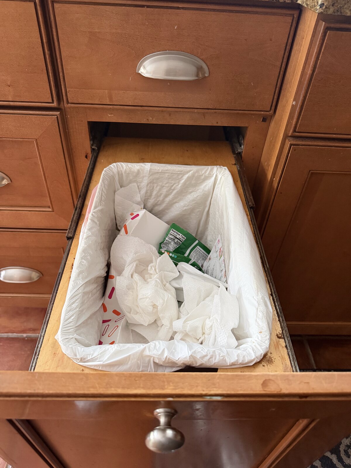Second angle of a custom wood housing enclosing a pull-out trash can